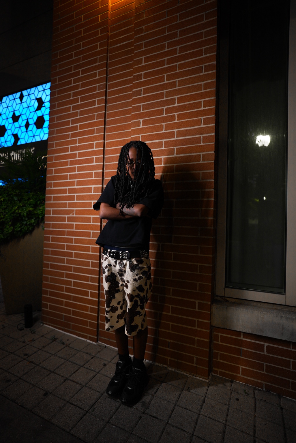 Kai September standing against a brick wall